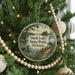 A circular ornament hanging on a Christmas tree, featuring a scenic image of Duck Lake State Park in Michigan.