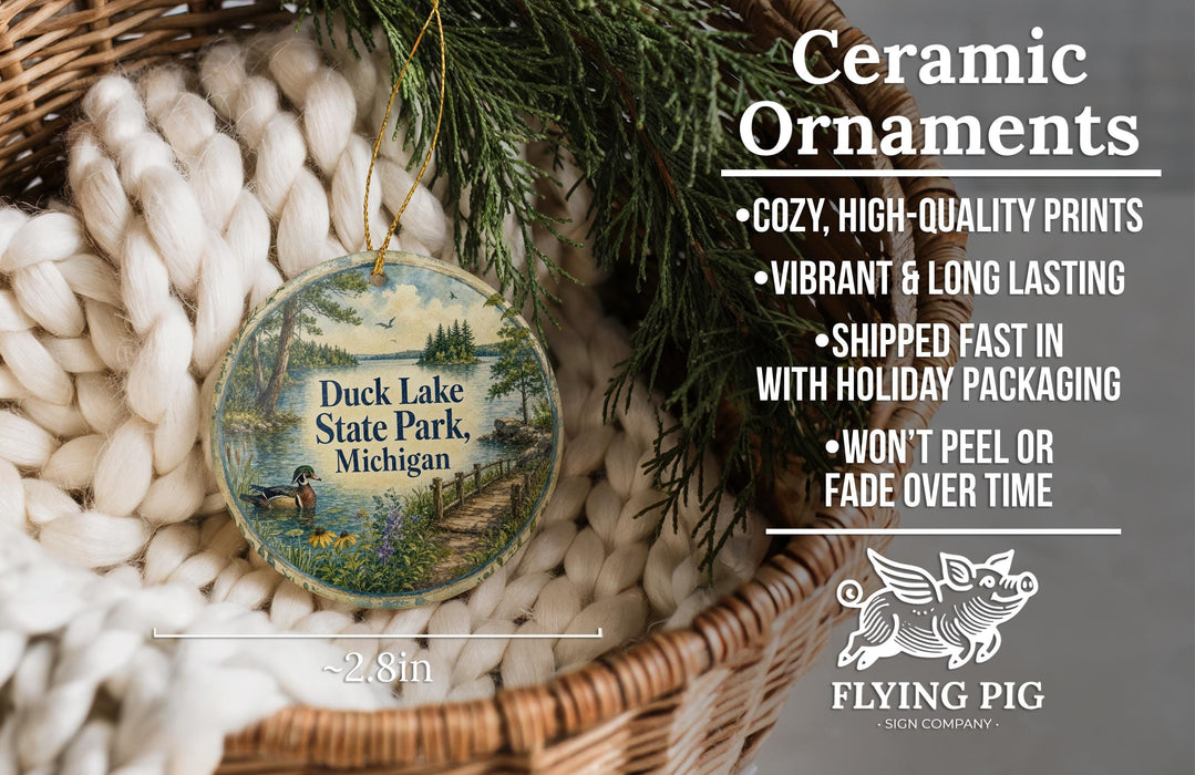 Ceramic ornaments, featuring a wooden ornament with a scenic image of Duck Lake State Park, Michigan, hanging from a wicker basket.