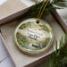 A decorative ornament in a box, featuring a scenic image of Duns Creek State Park in Florida.