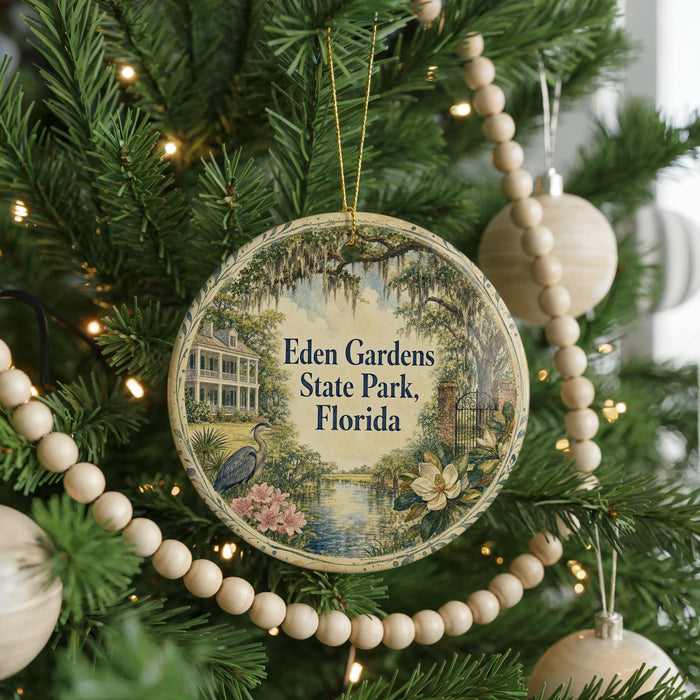 A round ornament hanging on a Christmas tree, featuring a scenic image of Eden Gardens State Park in Florida.