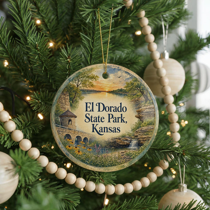 A round ornament on a Christmas tree, featuring a scenic landscape with a bridge and a waterfall, with the text "El Dorado State Park, Kansas" displayed prominently.