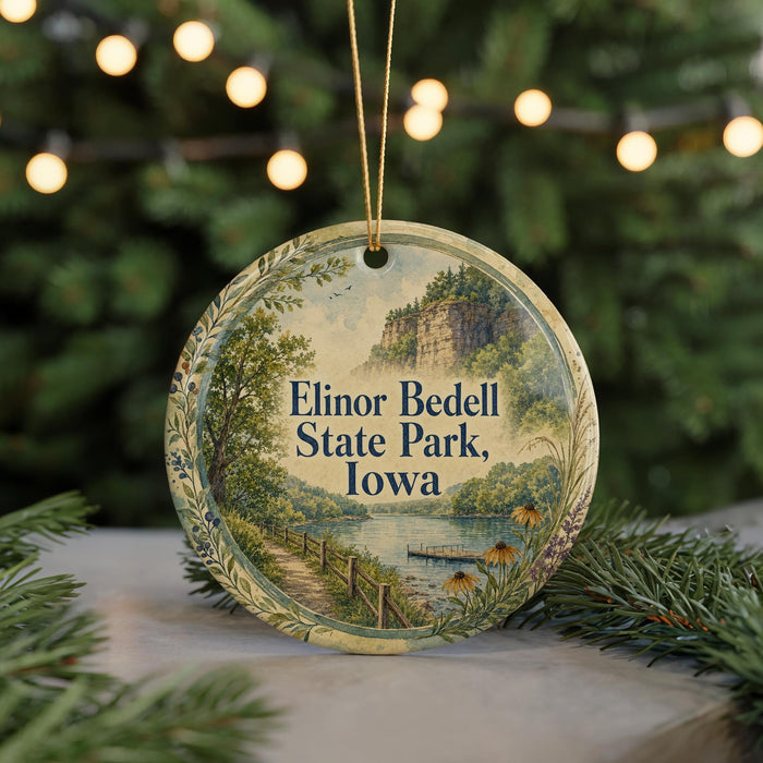 A round ornament with a scenic landscape of Elinor Bedell State Park, Iowa, featuring a lake, a bridge, and a mountain.