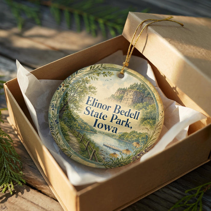 A decorative ornament in a box, featuring a scenic landscape with a path leading to a waterfall.