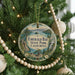 A round ornament hanging on a Christmas tree, featuring a scenic image of Emerald Bay State Park, California.