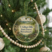 A round ornament hanging on a Christmas tree, featuring a scenic landscape of the F. Gilbert Hills State Forest in Massachusetts.