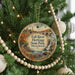 A circular ornament hanging on a Christmas tree, featuring a scenic image of Fall River Heritage State Park in Massachusetts.