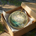 An ornament in a brown box, featuring a scenic image of Fanning Springs State Park, Florida.