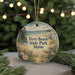 A round ornament with a beach scene and text, hanging on a string.