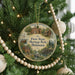 A round ornament hanging on a Christmas tree, featuring illustrations of historic buildings and landmarks in Delaware.