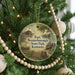 A round ornament hanging on a Christmas tree, featuring a scene from Fort Boone, Kentucky.