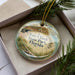 A decorative ornament in a box, featuring a picture of Fort Clinch State Park in Florida.