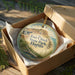 A decorative ornament in a box, featuring an illustration of Fort Clinch State Park in Florida.