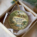 A round ornament with a painting of Fort Washington State Park, Maryland, hanging from a string.