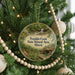 A round ornament hanging on a Christmas tree, featuring a scenic image of Franklin Creek in Illinois.