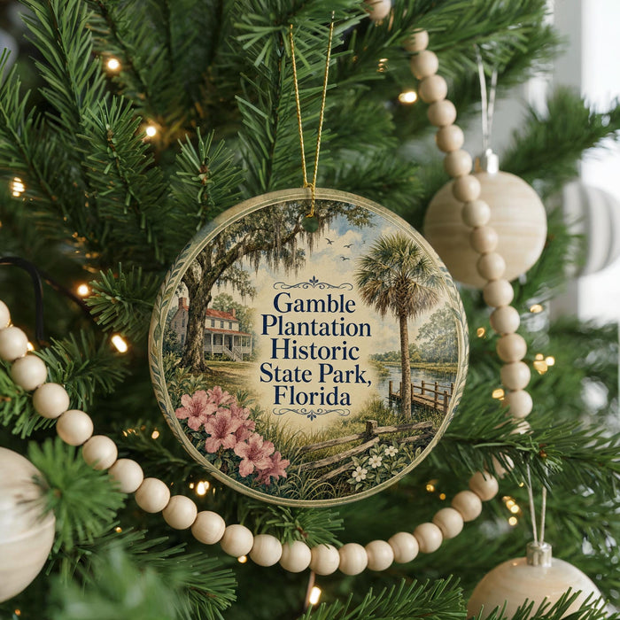 A round ornament hanging on a Christmas tree, featuring a scenic image of a historic park in Florida.