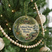 A round ornament hanging on a Christmas tree, featuring a scenic image of Gebhard Woods State Park, Illinois.