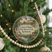 A round ornament hanging on a Christmas tree, featuring a scenic image of General Butler State Resort Park, Kentucky.