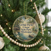 A round ornament hanging on a Christmas tree, featuring a scenic image of George Payne Cossar State Park in Mississippi.