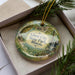 A decorative ornament in a box, featuring a scenic image of the Giant City State Park in Illinois.