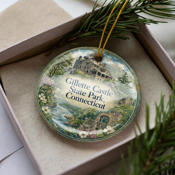 A decorative ornament in a box, featuring a castle and a scenic landscape.