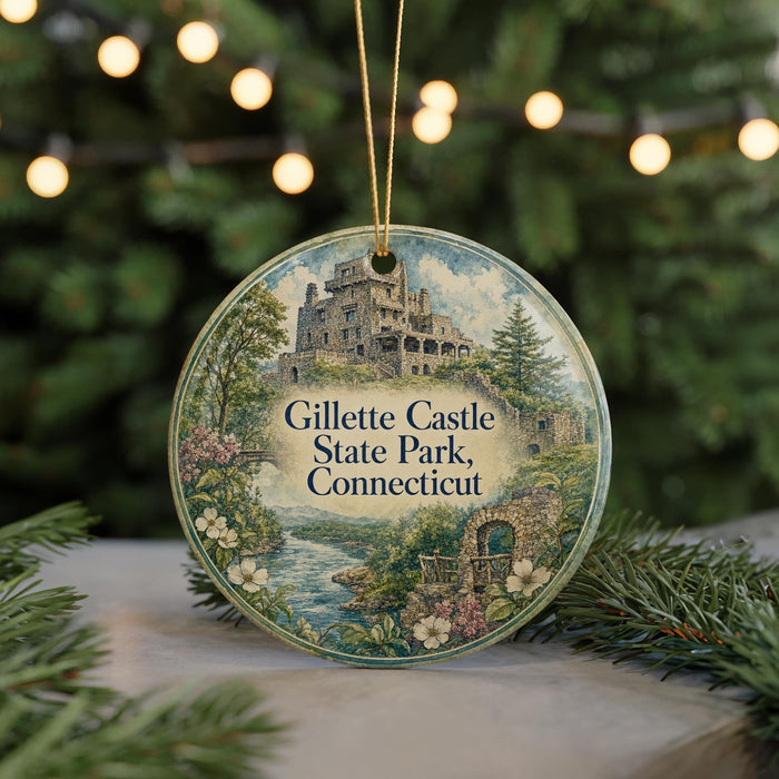 A round ornament with a castle and trees in the background, hanging on a string.