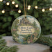A round ornament with a castle and trees in the background, hanging on a string.