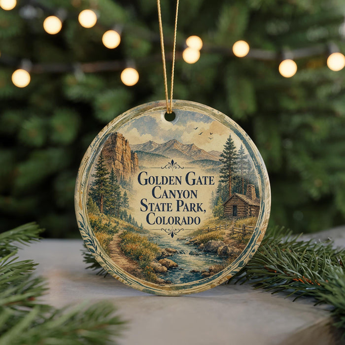 A round ornament featuring a scenic landscape of mountains, trees, and a cabin, with the text "Golden Gate Canyon State Park, Colorado" displayed prominently.