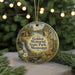 A round ornament with a scenic landscape featuring a waterfall, cabin, and deer, hanging from a string.