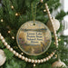 A round ornament hanging on a Christmas tree, featuring a scenic landscape with a bird in flight and text that reads "Goose Lake Prairie State Natural Area, Illinois".