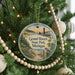 A round ornament hanging on a Christmas tree, featuring a scenic image of Grand Haven State Park, Michigan.
