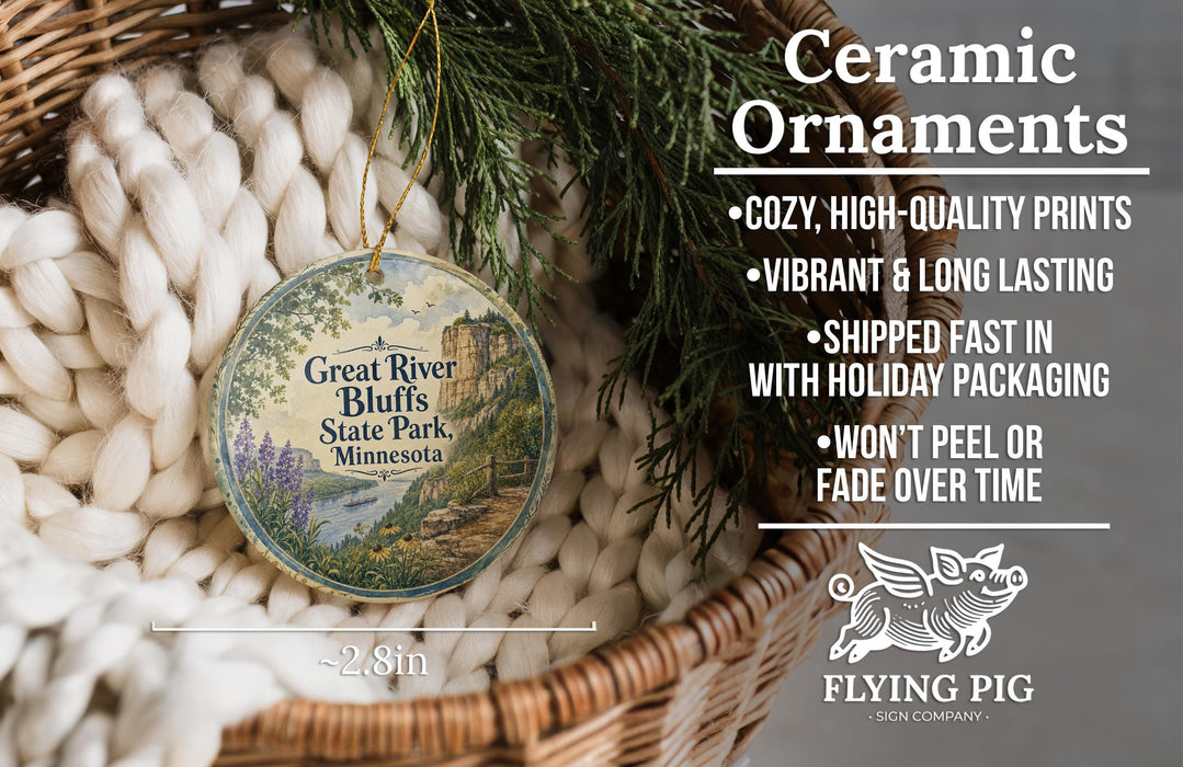 Ceramic ornaments, including a Great River Bluffs State Park ornament, are displayed in a basket with pine branches.