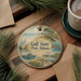 A circular ornament featuring a scenic view of Gulf State Park, Alabama, with a bird, a turtle, and a pier in the background.