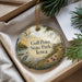 A round ornament with a scenic landscape of a lake, trees, and birds, hanging from a string.