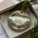 A decorative ornament in a box, featuring a scenic image of Gunpolder Falls State Park, Maryland.