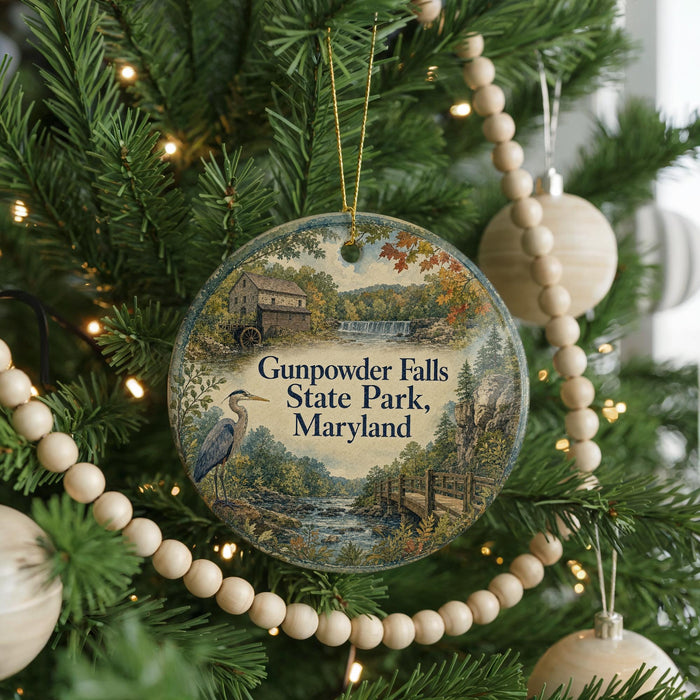 A round ornament hanging on a Christmas tree, featuring a scenic image of Gunpowder Falls State Park, Maryland.