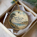 A round ornament with a scenic image of Half Moon Bay, California, featuring a lighthouse and a beach.