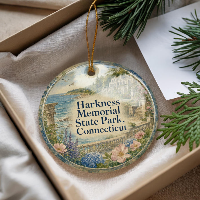 A decorative ornament with a scenic landscape of Harkness Memorial State Park, Connecticut, displayed in a box with pine branches.