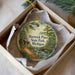 A decorative ornament in a box, featuring a scenic image of Hartwick Pines State Park, Michigan.