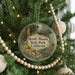 A round ornament hanging on a Christmas tree, featuring an illustration of Hendy Woods State Park, California.