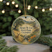 A round ornament with a scenic landscape featuring a deer, mountains, and a stream, hanging from a string.