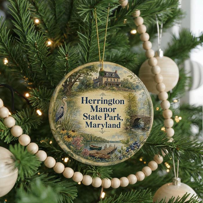 A round ornament hanging on a Christmas tree, featuring a scenic image of Herrington Manor State Park, Maryland.
