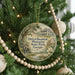 A round ornament hanging on a Christmas tree, featuring a scenic image of a plantation house surrounded by greenery.