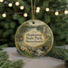 A circular ornament with a painting of Hopkinton State Park, Massachusetts, hanging on a string.