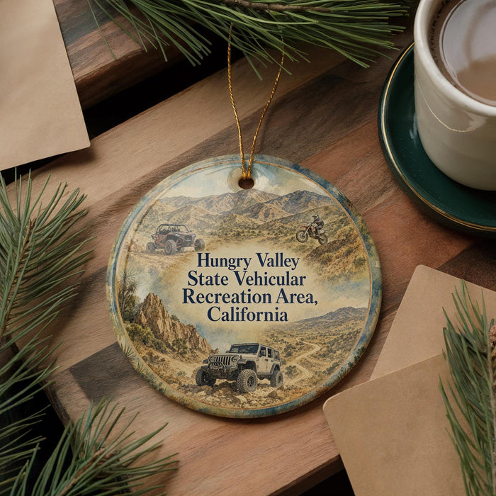 A round ornament featuring a jeep and mountains, with text that reads "Hungry Valley State Vehicular Recreation Area, California".