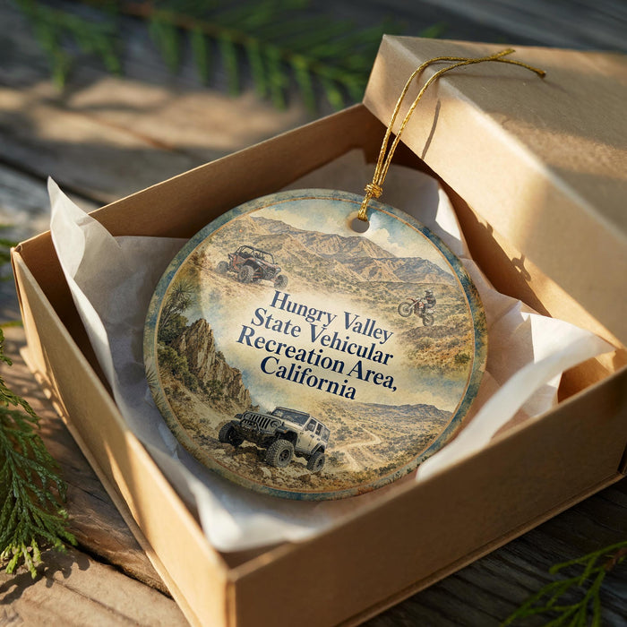 a round ornament with a picture of a jeep and a mountain landscape, placed inside a brown cardboard box.