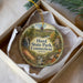 A decorative ornament in a box, featuring a scenic image of Hurd State Park in Connecticut.