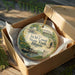 A decorative ornament in a wooden box, featuring an illustration of a canal and a bridge, with the text "I&M Canal State Trail, Illinois" prominently displayed.