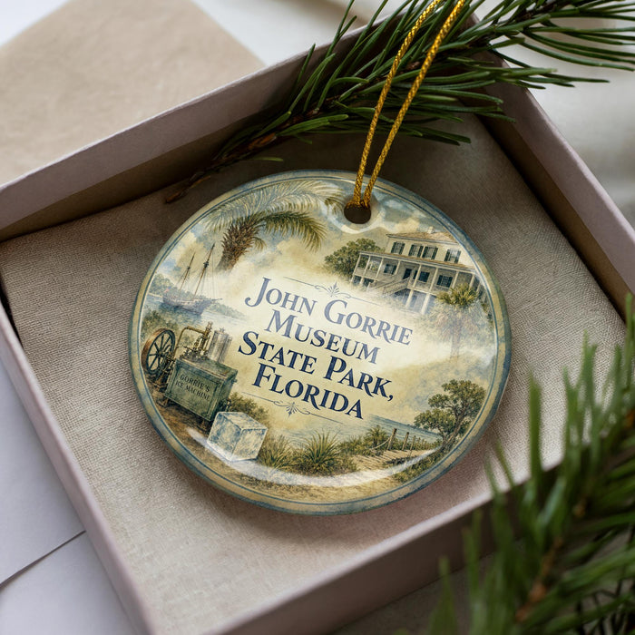 A decorative ornament in a box, featuring an illustration of a building and palm trees, with the text "John Gorrie Museum State Park, Florida" printed on it.