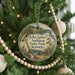 A round ornament hanging on a Christmas tree, featuring a scenic illustration of John James Audubon State Park in Kentucky.