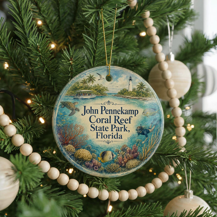 A round ornament hanging on a Christmas tree, featuring an illustration of a tropical beach scene with palm trees, a lighthouse, and a boat.